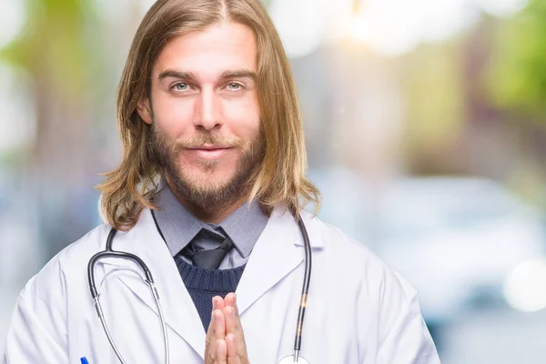 Młody Przystojny Lekarz Mężczyzna Długimi Włosami Białym Tle Modląc Się — Zdjęcie stockowe