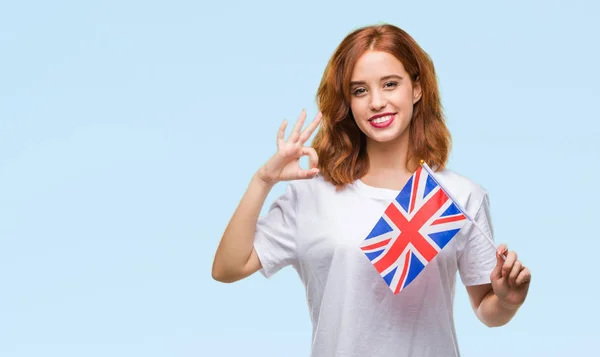 年轻美丽的妇女持有英国国旗在孤立的背景下做 标志与手指 优秀的标志 — 图库照片