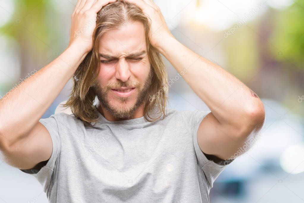 Young handsome man with long hair over isolated background suffering from headache desperate and stressed because pain and migraine. Hands on head.