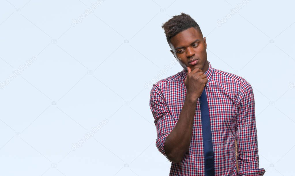 Young african american business man over isolated background with hand on chin thinking about question, pensive expression. Smiling with thoughtful face. Doubt concept.