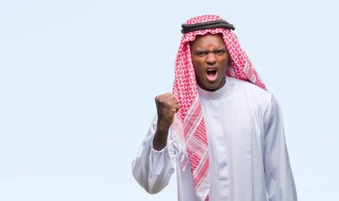 Geleneksel keffiyeh izole arka plan öfkeli ve sinirli sinirli ve öfke ile bağırarak süre öfkeli yumruk yükselterek üzerinde giyen genç Arapça Afrika adam. Öfke ve agresif kavramı.