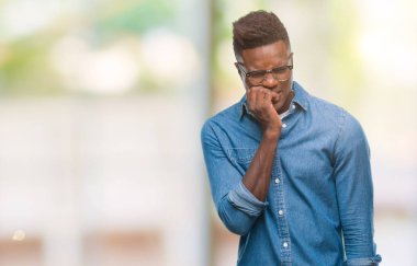 Genç Afro-Amerikan adam stresli ve gergin ile izole arka plan üzerinde tırnak ısırma dudaklarından eller. Anksiyete sorunu.