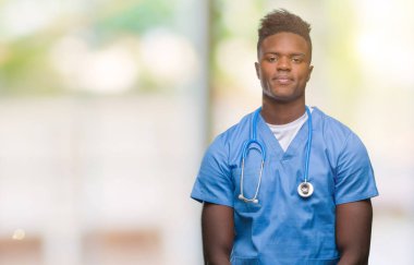 Genç Afro-Amerikan Doktor adam cerrah üniforması ile ciddi ifade yüzünde izole arka plan üzerinde. Basit ve doğal kameraya bakıyor.