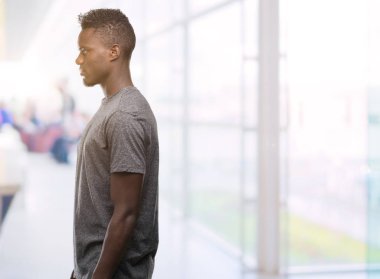 Tarafına, seyir gri t-shirt giyen genç Afro-Amerikan adam sakin ol kendine güvenen gülümseme ile doğal yüz pozuyla profili.