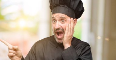 Kıdemli uzak yan parmak ile işaret Şef şapkalı adam, yemek