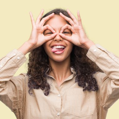 Genç İspanyol iş kadını, dilini parmaklarının arasından baktığını yapışmasını dürbün gibi ok jest yapıyor. Deli ifade.