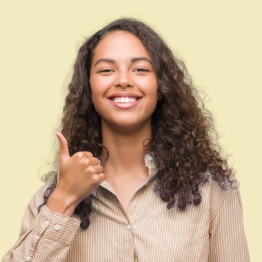 Genç İspanyol iş kadını mutlu yaşasın el hareketini yapıyor. Kameraya bakarak başarı gösteren ile ifade onaylama.