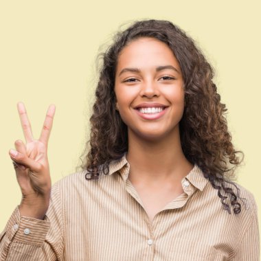 Gösterilen ve parmakları ile işaret genç İspanyol iş kadını ikincisi ise kendinden emin ve mutlu gülümseyerek.