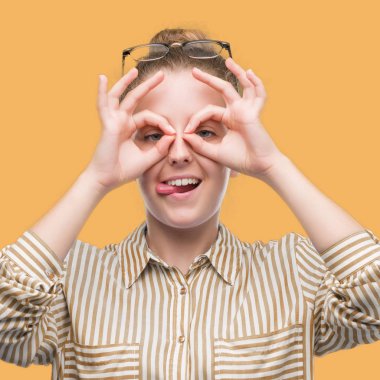 Genç Sarışın iş kadını, dilini parmaklarının arasından baktığını yapışmasını dürbün gibi ok jest yapıyor. Deli ifade.