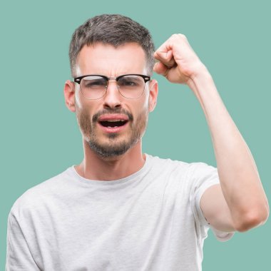 Genç yetişkin adam kızgın dövme ve kızgın yetiştirme hayal kırıklığı ve öfke ile bağırarak süre öfkeli yumruk. Öfke ve agresif kavramı.