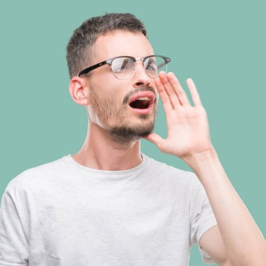 Genç bağırarak ve ağzı üzerinde el ile yan için çığlık yetişkin adam dövme. İletişim kavramı.