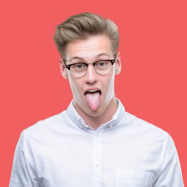 Genç yakışıklı sarışın adam dilini out komik ifade ile mutlu. Duygu kavramı.