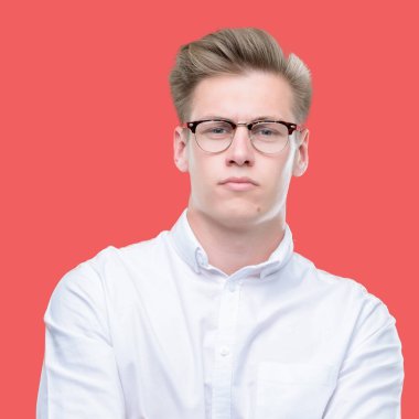 Genç yakışıklı sarışın adam şüpheci ve sinir, onaylamayan ifade yüz çapraz kolları üzerinde. Negatif kişi.