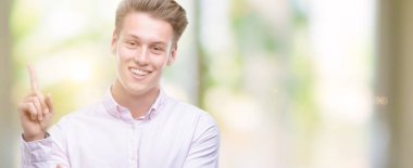 Genç yakışıklı sarışın adam el ve parmak ile tarafına işaret çok mutlu