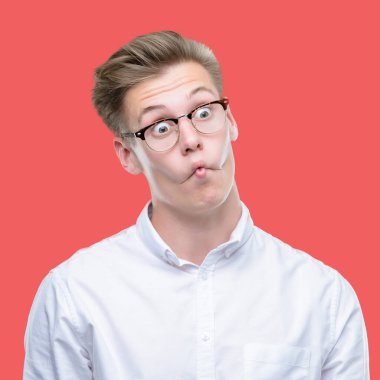 Genç yakışıklı sarışın adam yapma balık yüz dudaklı, çılgın ve komik bir jest. Komik ifade.