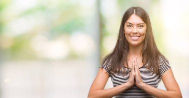 Genç güzel İspanyol kadın ellerle birlikte AF emin gülümseyen için soran dua.