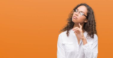 Çene düşünme hakkında soru, dalgın ifade üzerine el ile güzel genç İspanyol kadın. Düşünceli yüzüyle gülümsüyor. Şüphe kavramı.