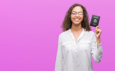 Amerika Birleşik Devletleri pasaport ile ayakta ve diş gösterilen kendine güvenen bir gülümsemeyle gülümseyerek mutlu bir yüz tutan genç İspanyol kadın