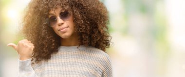 El ve parmak ile yukarı dönük mutlu yüz gülümseyen ile çizgili süveter giyen Afrikalı-Amerikalı kadın