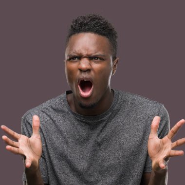 Kızgın ve silah ile başarı için deli kutluyor gri t-shirt giyen genç Afro-Amerikan adam kaldırdı ve heyecanlı çığlık gözler kapalı. Kazanan kavramı