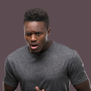 Çünkü mide üzerinde el ile gri t-shirt giyen genç Afro-Amerikan erkek hazımsızlık, ağrılı hastalık hasta hissediyor. Ağrısı kavramı.