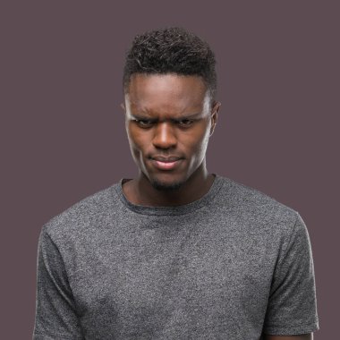 Gri t-shirt şüpheci ve sinir, papatyanın üzgün sorunu nedeniyle giyen genç Afro-Amerikan adam. Negatif kişi.