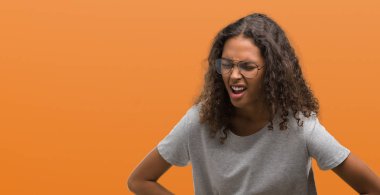 Güzel genç İspanyol kadın el ile mide üzerinde çünkü gözlük hazımsızlık, ağrılı hastalık hasta hissediyor. Ağrısı kavramı.