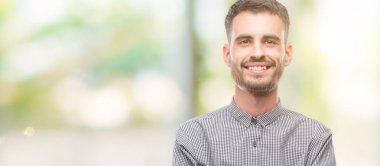 Genç hipster adam mutlu yüz ile gülümseyerek kameraya seyir silah geçti. Olumlu bir kişi.