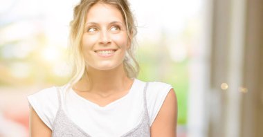 Genç, güzel bir kadın, düşünüyor, yukarı bakıyor şüphe ve merakını dile getiriyor.