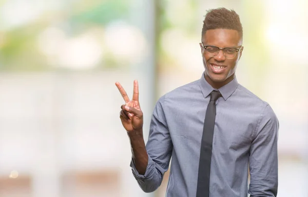 Young african american business man over isolated background smiling with happy face winking at the camera doing victory sign. Number two.