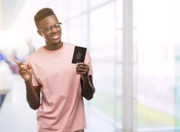 Młody Człowiek African American Paszportem Kanadyjskim Bardzo Szczęśliwy Wskazując Dłoni — Zdjęcie stockowe