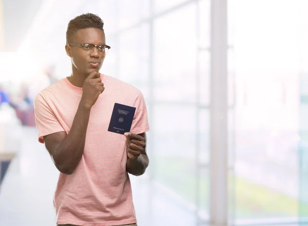 Joven Afroamericano Con Pasaporte Alemán Cara Seria Pensando Pregunta Idea — Foto de Stock