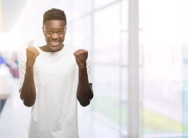 Unga Afroamerikanska Man Klädd Vit Shirt Firar Överraskad Och Förvånad — Stockfoto