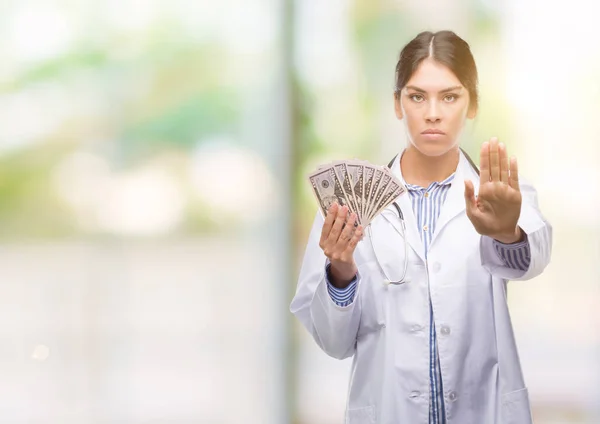 Joven Doctora Hispana Sosteniendo Dólares Con Mano Abierta Haciendo Stop —  Fotos de Stock