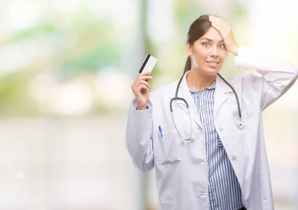 Jovem Médica Hispânica Segurando Cartão Crédito Estressado Com Mão Cabeça — Fotografia de Stock