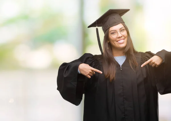 卒業の帽子と制服探して顔に笑顔と自信を持って 誇りと幸せな指で自分を指して着て若いヒスパニック系女性 — ストック写真