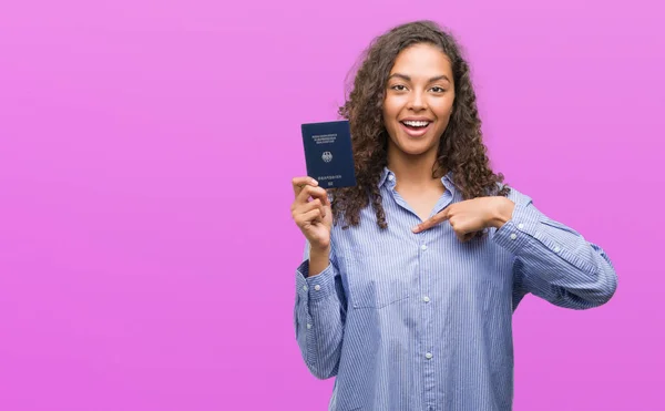 Jovem Hispânica Segurando Passaporte Alemanha Com Rosto Surpresa Apontando Dedo — Fotografia de Stock