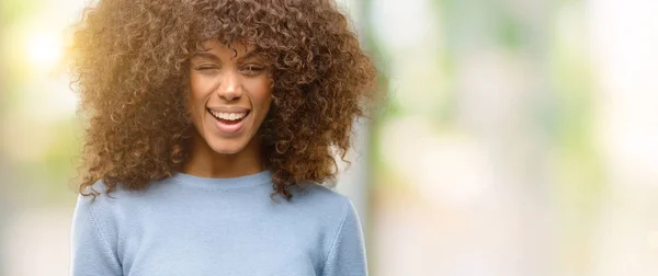 Mujer Afroamericana Vistiendo Suéter Guiñando Ojo Mirando Cámara Con Expresión — Foto de Stock