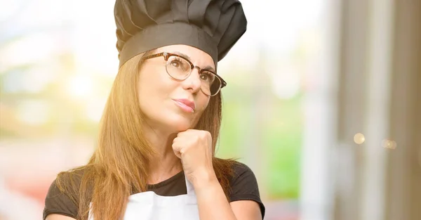 中年厨师妇女穿着厨师围裙思考和寻找表达怀疑和疑惑 — 图库照片