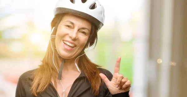 Middle Age Cyclist Woman Using Earphones Pointing Away Side Finger — Stock Photo, Image