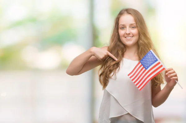 Young Blonde Woman Holding Flag Usa Surprise Face Pointing Finger — Stock Photo, Image