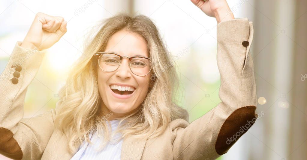 Young beautiful woman happy and excited celebrating victory expressing big success, power, energy and positive emotions. Celebrates new job joyful