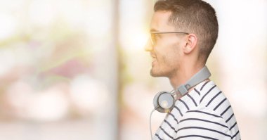 Yakışıklı genç giyen kulaklık tarafına arıyorum dostum, kendine güvenen gülümseme ile doğal yüz pozuyla profil sakin ol.