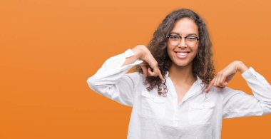 Yüzünde gülümseme ile kendinden emin görünüyorsun, kendini gururlu ve mutlu parmakları ile işaret güzel genç İspanyol kadın.