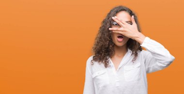 Mahcup ifadeyle parmaklarımın arasından yüz ve gözler el ile kapsayan şok bakmak güzel genç İspanyol kadın arıyor.