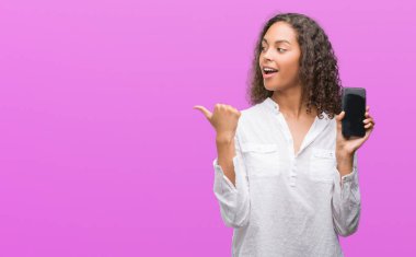 İşaret ve başparmak kadar mutlu yüz gülümseyen tarafı ile gösterilen smartphone kullanan genç İspanyol kadın