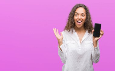 Kocaman bir gülümseme ile çığlık zaferini kutluyor ve ellerini kaldırdı smartphone çok mutlu ve heyecanlı, kazanan ifade kullanan genç İspanyol kadın