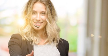 Genç kadın işleç çağrı merkezi el sıkışma poz karşılama, güven ve başarı kavramı ifade, tebrik ellerini tutar