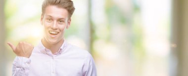 Genç yakışıklı sarışın adam el ve parmak ile yukarı dönük mutlu yüz gülümseyen ile