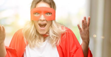 Genç cape mutlu ve ifade wow jest tezahürat giyen kahraman kadın süper